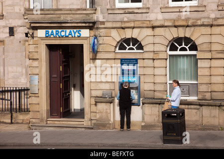 Alnwick, Northumberland, England, UK. Barclays Bank mit Person mit Loch in der Wand ATM Stockfoto