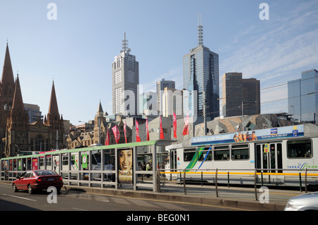 Straßenbahnen und Straßenbahn halten am Princes Bridge über den Yarra River Melbourne Australien mit St Pauls Cathedral und Hochhaus Wolkenkratzer Stockfoto