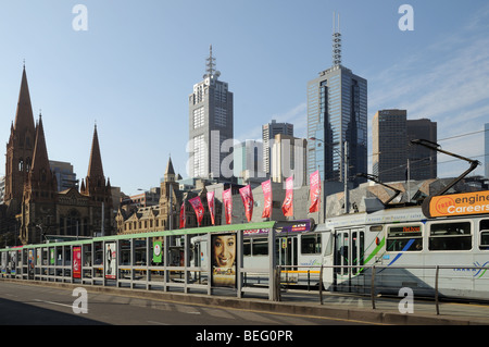 Straßenbahnen und Straßenbahn halten am Princes Bridge über den Yarra River Melbourne Australien mit St Pauls Cathedral und Hochhaus Wolkenkratzer Stockfoto