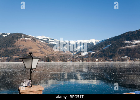 Zell am See Österreich Europa. Panoramablick vom Stadtpark über den zugefrorenen Zeller See See und schneebedeckten Alpen im winter Stockfoto