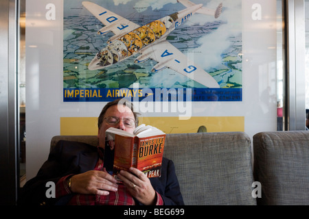 Geschäftsreisende, die für Passagiere am Flughafen Heathrow T5 Roman beim Zwischenstopp in der British Airways Galleries Club lesen Stockfoto