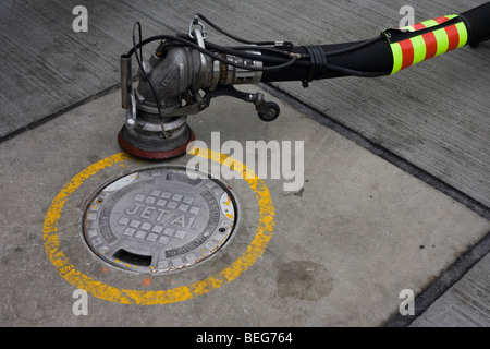 Ein Refueller Düse ist bereit, zu Boden Reservoir von Flugkraftstoff Jet A1 auf dem Vorfeld konkrete in Heathrow verbunden werden Stockfoto