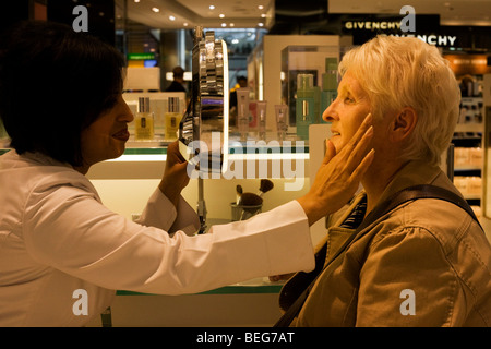 Eine ältere Dame erhält eine Beratung von professionellen Kosmetikerin in Clinique Bar am World Duty Free im Flughafen Heathrow T5 Stockfoto