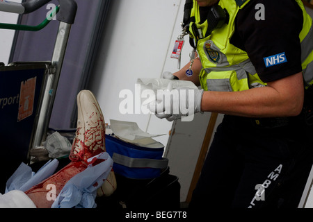 Ein NHS-Sanitäter-Responder besucht Lady Passagier in Heathrows terminal 3, stolperte und schlecht gashed ihr Bein hat. Stockfoto