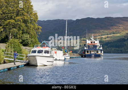 Motorschiffe Vergnügen vor Anker am Caledonian Canal in Fort Augustus Sco mit Herrn der Glens und Loch Ness im Hintergrund. Stockfoto