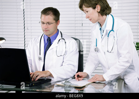 Zwei Ärzte arbeiten in der Diagnose der medizinischen Aufzeichnungen oder Ergebnisse, die sie vor ihnen haben. Stockfoto