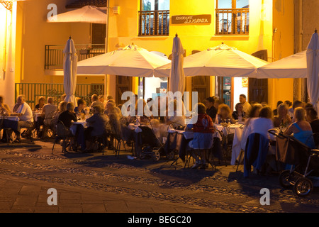 Alghero, Sardinien, Italien. Nachtaufnahme mit Menschen vor einem Restaurant Essen Stockfoto