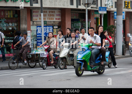 Menschen, die Reiten, Mopeds und Fahrräder in Shanghai China Stockfoto