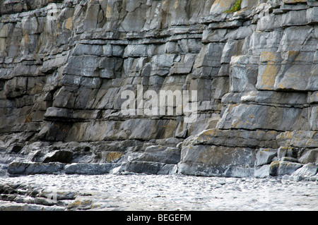 Blasse graue Kalkstein Schichten auf einer Küste Felswand Stockfoto