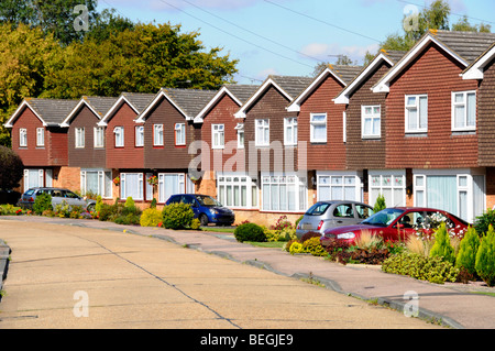 Reihe von Häusern in Wohnstraße von Immobilien-Gehäuse Grundstücksentwicklung identische Einfamilienhäuser individuelle Gärten & Auto Auffahrt England GB Stockfoto