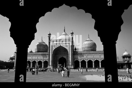 Die Jama Masjid Moschee in Old Delhi umrahmt von kunstvoll geschnitzten Mughal Steinsäulen und Arch. Stockfoto