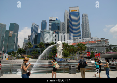 Touristen fotografieren vor der Merlion und Stadt Skyline, Singapur Stockfoto