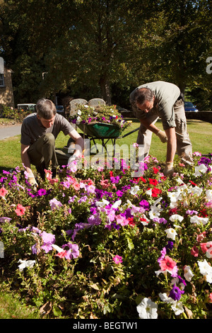 England, Cambridgeshire, Huntingdon, Hartford Pfarrei Kirchhof, Rates Arbeiter Aufrechterhaltung Blumenbeet Stockfoto