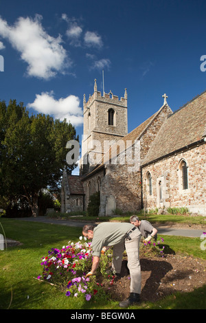 England, Cambridgeshire, Huntingdon, Hartford Pfarrei Kirchhof, Rates Arbeiter Aufrechterhaltung Blumenbeet Stockfoto