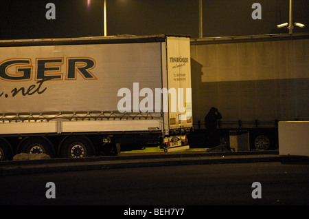 Calais, Flüchtlinge, die nach Großbritannien zu gelangen hofft Klettern LKW auf Parkplätzen auf nightime Stockfoto