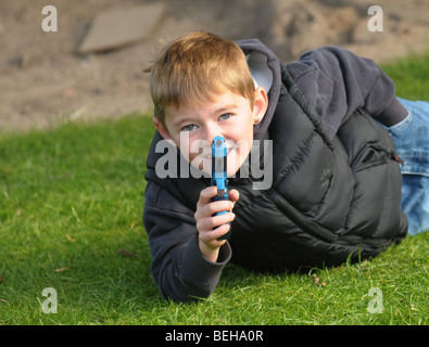 Kleiner Junge spielt mit Spielzeugpistole. Stockfoto