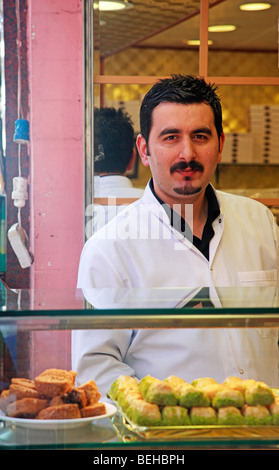 Türkischer Mann Baklava und anderen Süßigkeiten und Gebäck in einem Geschäft zu verkaufen. Das Basar-Viertel, Istanbul, Türkei Stockfoto