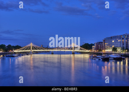 Dämmerung fällt über die Themse und die Albert Bridge in London England. Stockfoto