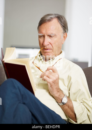 Senior Woman Buch zu Hause Stockfoto