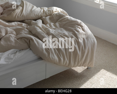 Ungemachten Bett mit gekräuselten Decke Stockfoto