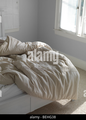 Ungemachten Bett mit gekräuselten Decke Stockfoto