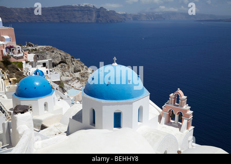 Griechische weiße Kirchen mit blauen Kuppeln mit Blick aufs Meer, Oia, Santorini, Kykladen, Griechenland. Stockfoto