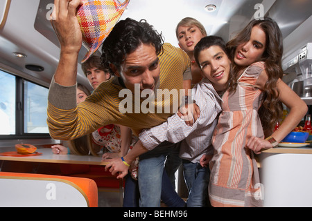 Teenager kämpfen, seinen Weg durch eine Gruppe von Menschen in einem Reisemobil Stockfoto