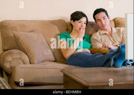 Mitte erwachsener Mann und eine junge Frau vor dem Fernseher und Essen popcorn Stockfoto