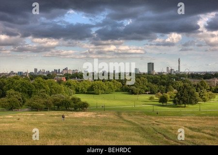 Der Blick auf London von Primrose Hill als die Sonne taucht tief im Westen. Schwere Wolken sitzen vor einem blauen Himmel. Stockfoto