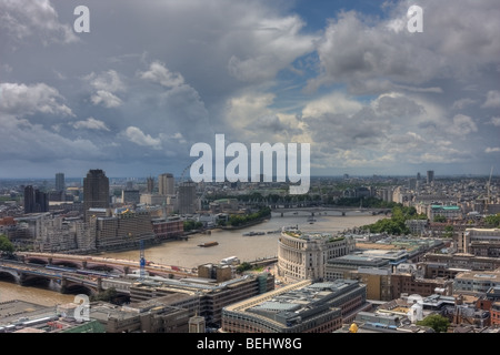 Blick auf die Themse, die Spitze der St. Pauls Cathedral, mit einem dramatischen Gewitterhimmel Overhead. Stockfoto