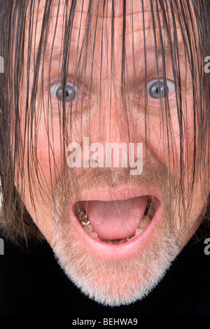 Wild aussehender Mann mit piercing Augen und langen Haaren. Stockfoto