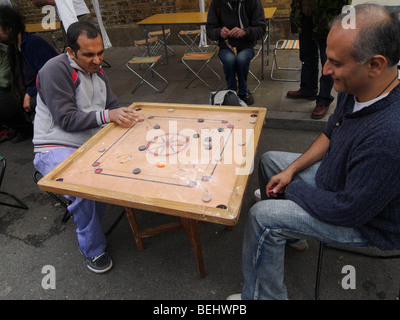 Spielen Sie das Tabletop Spiel Carrom in Brick Lane, London, England. Stockfoto