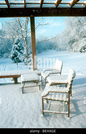 Neue Schnee auf Deck und Gartenmöbel im Winter Morgenlicht leuchtende besdie das Haus, Midwest USA Stockfoto