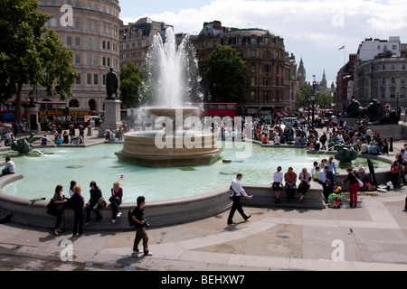 Trafalgar Square in London England im Sommer 2009. Touristen sitzen die Brunnen bei starkem Sonnenschein. Stockfoto