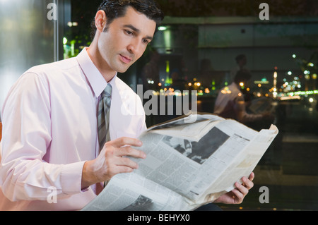 Geschäftsmann, lesen eine Zeitung in einer Flughafen-lounge Stockfoto