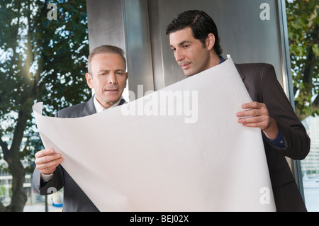 Zwei Geschäftsleute diskutieren eine Blaupause Stockfoto