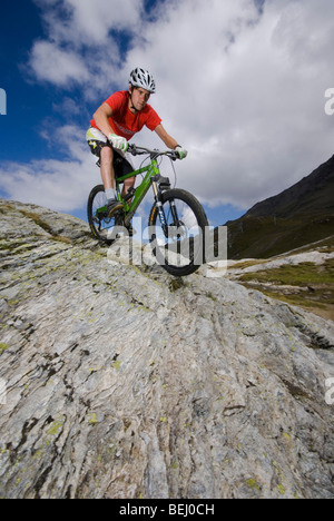 Ein Mountainbiker reitet einen felsigen Pfad in den Bergen in der Nähe von Les Arcs in den französischen Alpen. Stockfoto