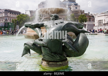 Bronzeskulptur von Meermann in Trafalgar Quadrat, London England, mit Brunnen hinter. Im Sommer 2009 übernommen. Stockfoto