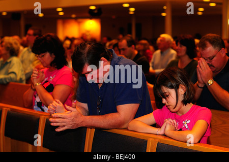 Eine Familie betet zusammen in einer katholischen Kirche. Stockfoto