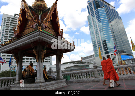 Zwei Mönche gehen vorbei an einem buddhistischen Schrein vor den Toren der Hua Lamphong Tempel in Bangkok. Stockfoto