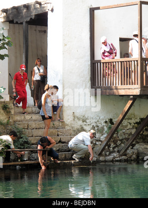 Menschen für Wasser vom Fluss zu erreichen. Bei Dervis Tekija in Blagaj auf der Buna Fluss Quelle. Stockfoto