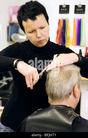 Ein Friseur trimmen ein mans Haar in einem Salon in UK Stockfoto