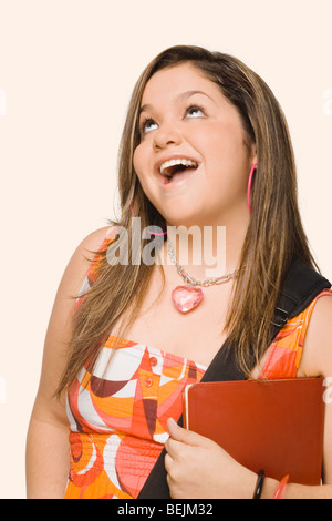 Nahaufnahme einer jungen Frau hält ein Tagebuch und lächelnd Stockfoto
