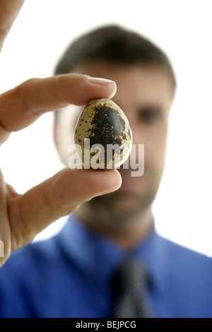 Geschäftsmann hält eine Wachtel fragile Ei, selektiven Fokus Stockfoto