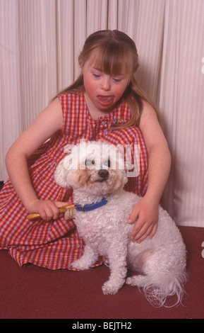 kleines Mädchen mit Down-Syndrom Pflege ihres Hundes Stockfoto