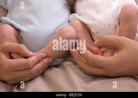 Eltern demonstrieren Containment hält für Frühgeborene, eineiigen Zwillingen, 11 Wochen alt, geboren 10 Wochen zu früh Stockfoto