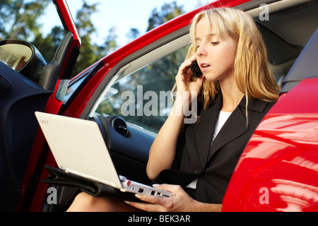 Frau saß im Auto mit laptop Stockfoto
