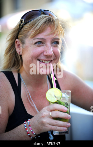 Eine Frau genießt einen Mojito-Cocktail in einer Bar am Meer in kalkan Stockfoto