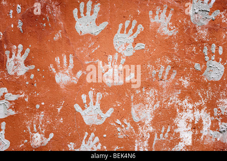 Betonwand rot verziert mit lustigen Prints von Händen Stockfoto