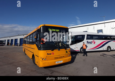 Gelber Schulbus und Coach bei Transport Unternehmen erste Busdepot und Hauptsitz in Aberdeen, Scotland, UK Stockfoto